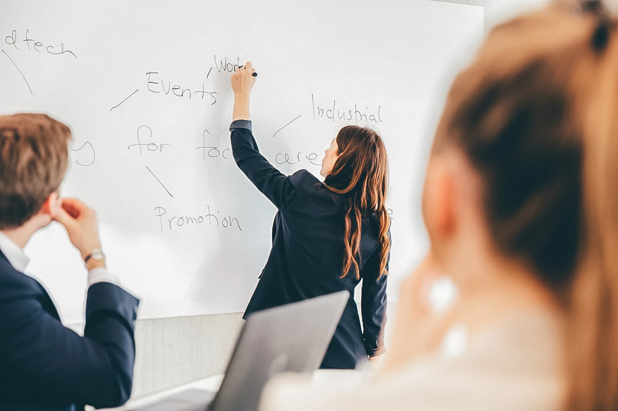 person writing on a white board